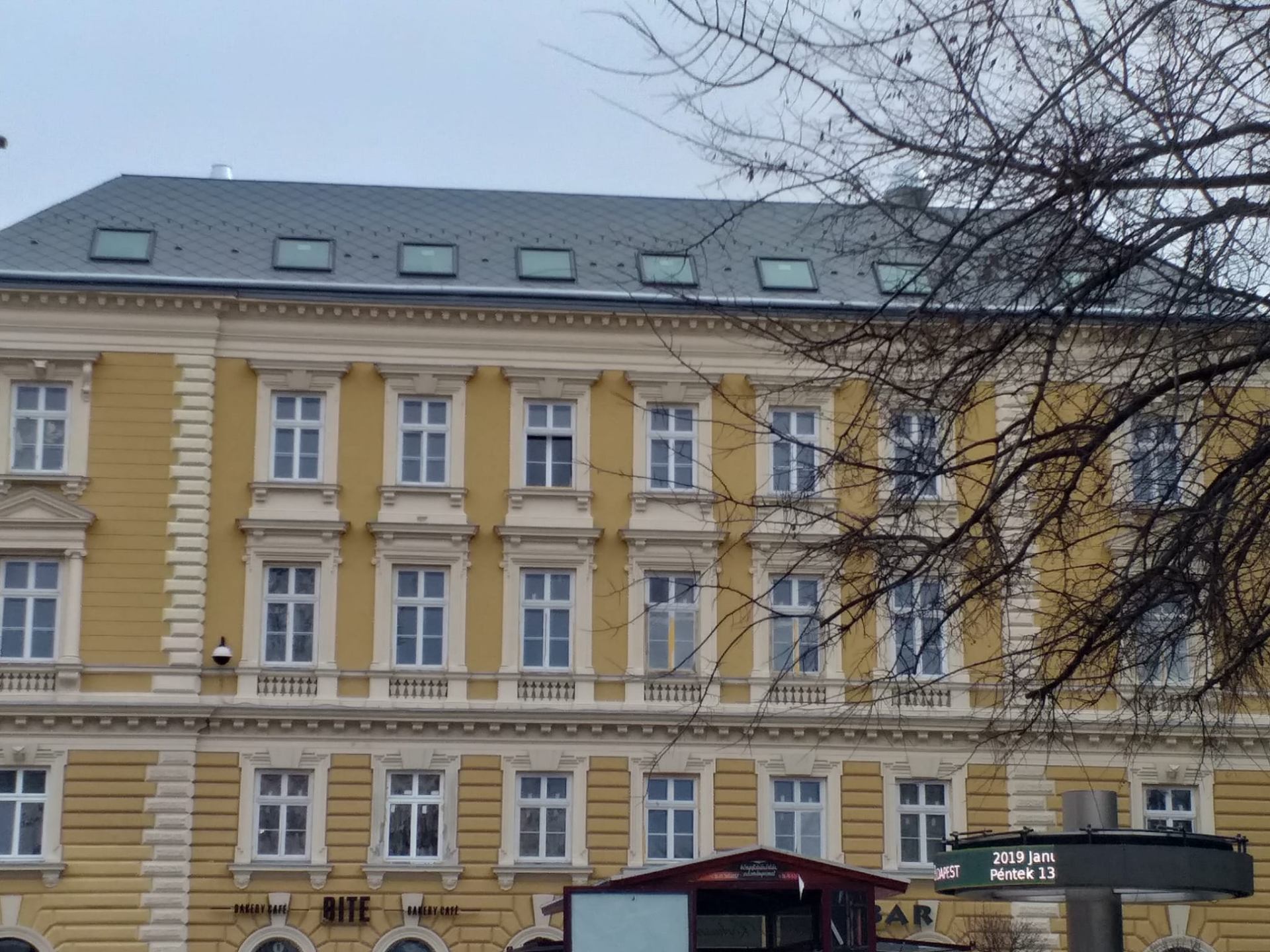 Fațadă clasică renovată cu finisaj galben și ornamente albe